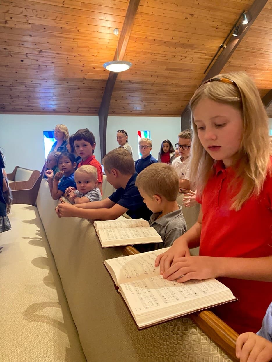 Children with hymnals in chapel